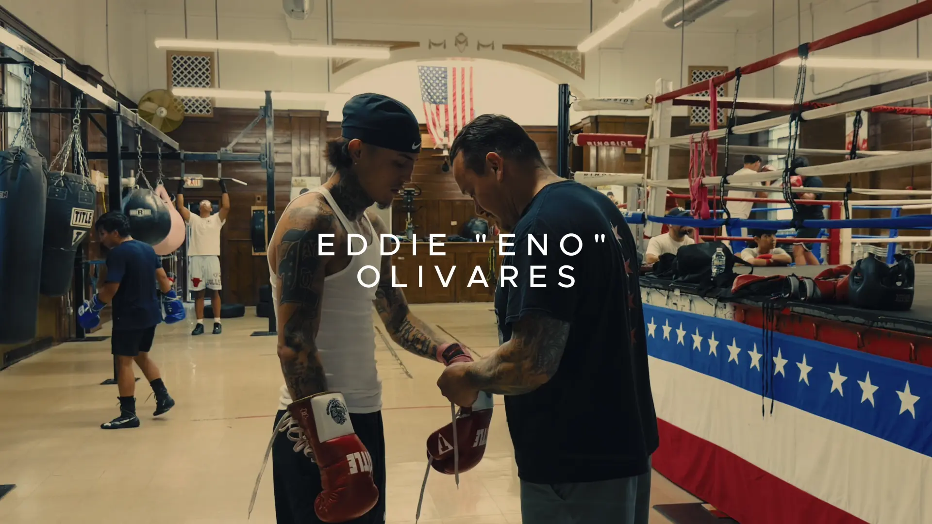 Boxer having his gloves prepared beside a boxing ring